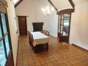A dining area with a table and chairs, a chandelier, and a fireplace. - Welcoming 2-bedroom house in charming Motreff for your getaway (Motreff)