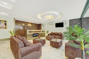 A hotel reception area with a marble reception desk, plush seating, and a chandelier. - Hotel O Le Grande Hotel & Banquet (Patna)