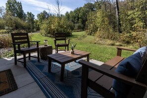 An outdoor seating area with wooden furniture and a rug. - Beautiful cozy 2-bedroom cottage with a woodburning stove and AC in Duluth (Duluth)
