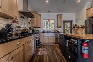 A modern kitchen with wooden cabinets, a stainless steel range, and a built-in oven.