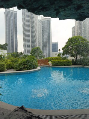 A swimming pool with a view of high-rise buildings in the background. - Hotel Residences at Acqua- Novotel Suites (Mandaluyong City)