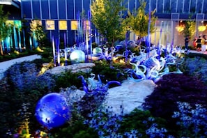 Un jardin agrémenté d’éléments sculpturaux, avec un bâtiment en arrière-plan.