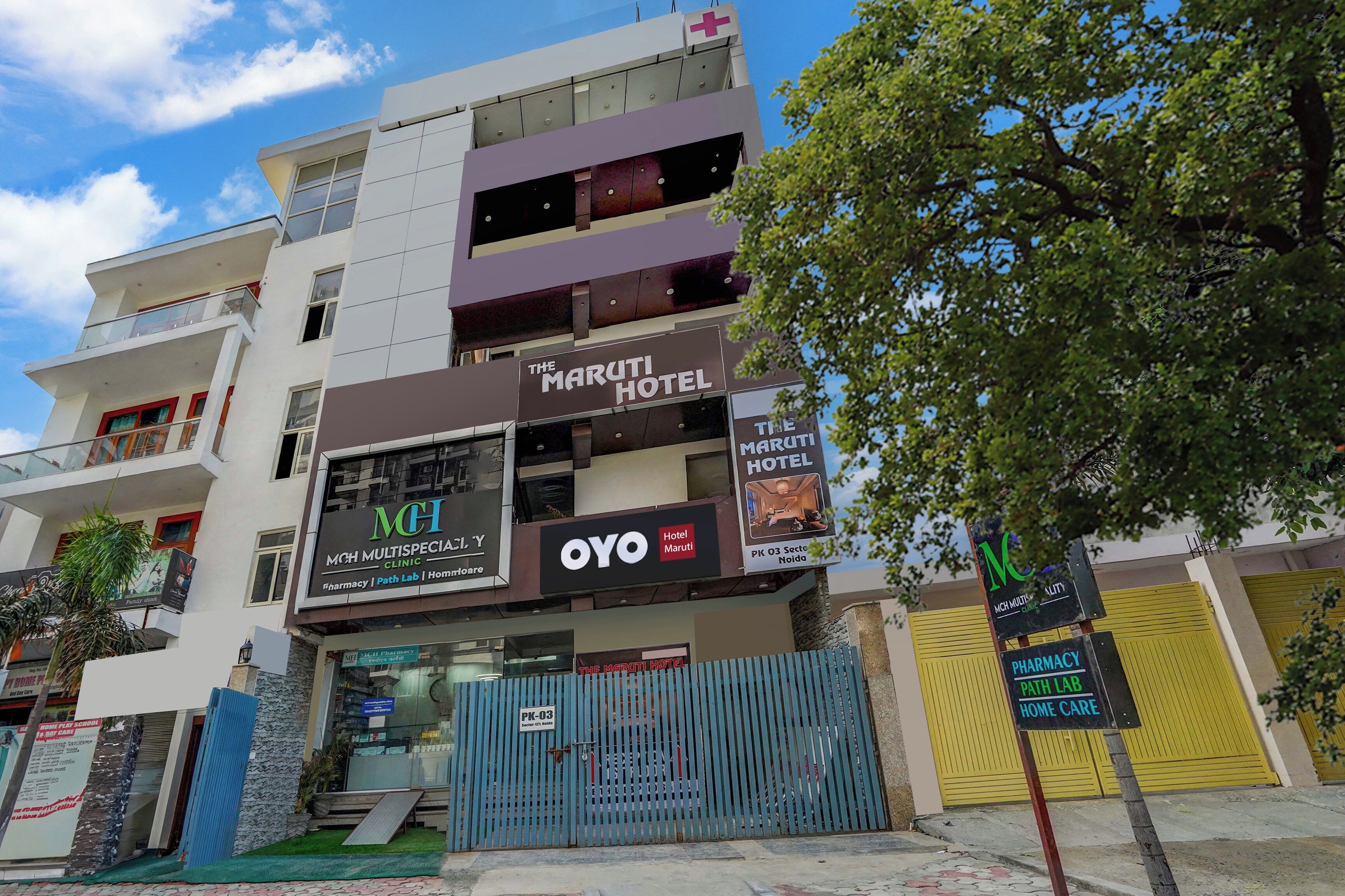 A multi-story building with a sign for 'The Maruti Hotel' and 'MCH Multispecialty Clinic'.