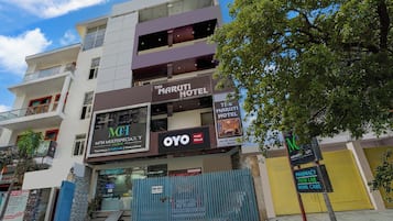 A multi-story building with a sign for 'The Maruti Hotel' and 'MCH Multispecialty Clinic'.