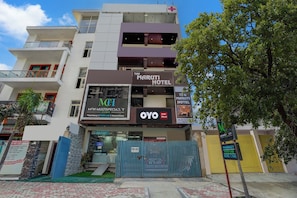 Un edificio de varios pisos con una farmacia, una clínica y un hotel llamado 'The Maruti Hotel'.