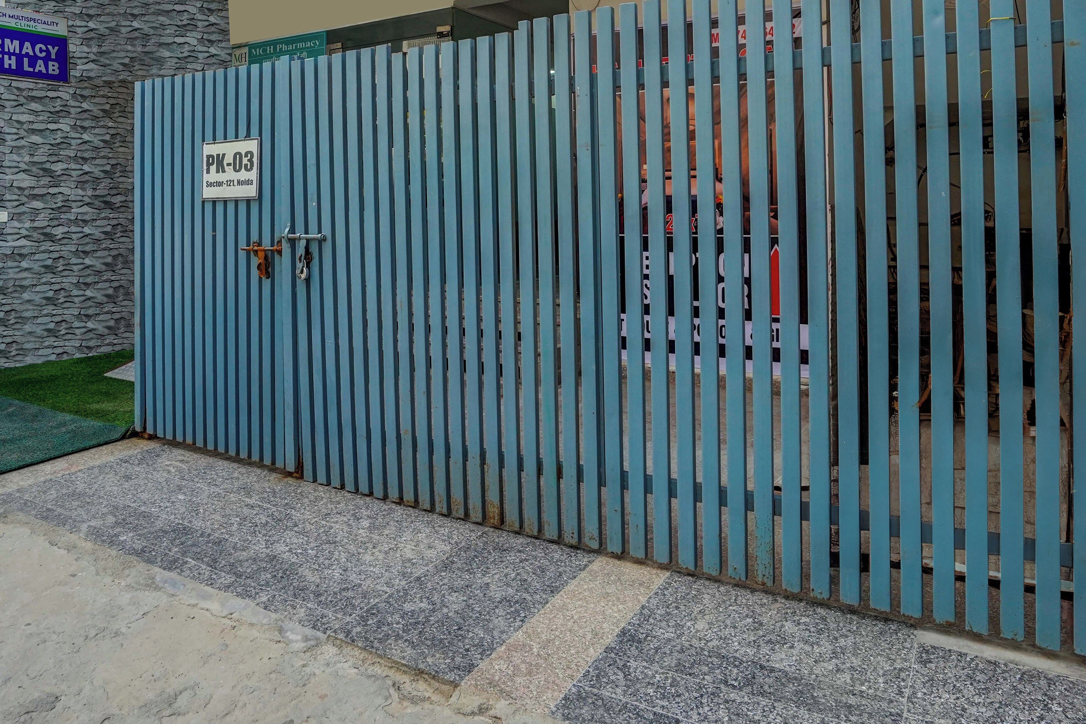 A gated entrance with a sign indicating 'Sector-121, Noida.'