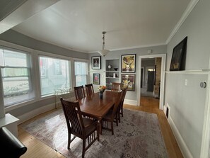 A dining area with a wooden table and chairs, a patterned rug, and a ceiling fan. - 2-bedroom apartment in enchanting Milwaukee with AC comfort (Milwaukee)
