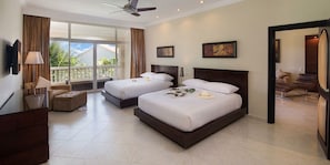 Habitación de hotel con dos camas, balcón, televisor y escritorio.