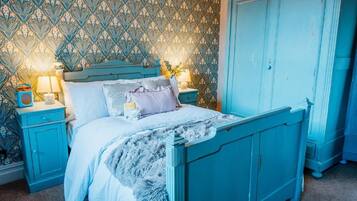 Une chambre à coucher comprenant un lit, des tables de chevet, une commode et une armoire.