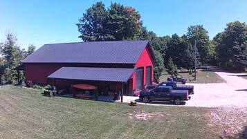 A red and black building with a covered area and a gravel driveway.
