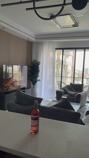 A modern living room with a flat-screen TV, a potted plant, and a sofa. - Gorgeous 1-bedroom apartment in Nairobi kilimani perfect for your stay (Nairobi)