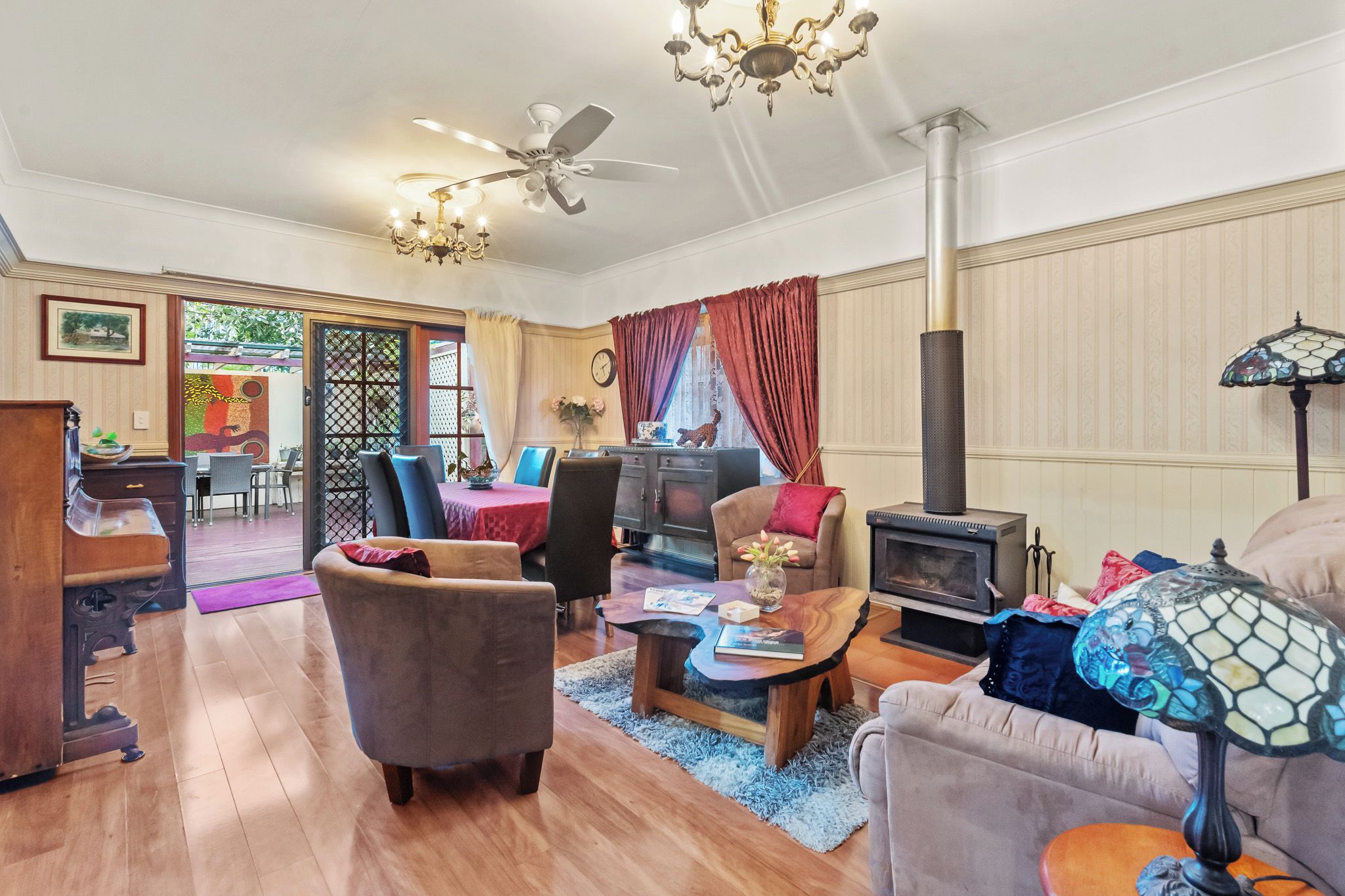 A spacious living room with a fireplace, a dining area with a table and chairs, and a cozy seating area with a sofa and armchairs.