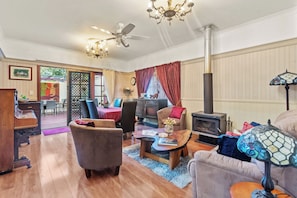 Un salón amplio con chimenea, un comedor con mesa y sillas, y una zona de estar acogedora con un sofá y sillones.