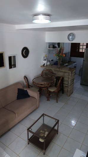 A living room with a sofa, a round table, and a coffee table. - Privê das ondas Casa 6 (Ipojuca)
