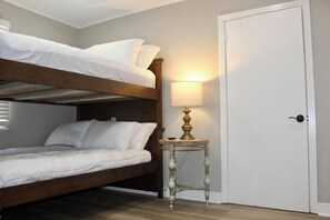 A bunk bed room with a small table and a lamp. - The Dettor House  (Sardis)
