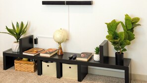 A black console table with a globe, books, and plants. - Vrbo Property (San Marcos)