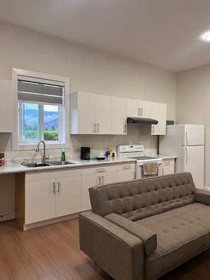 A modern kitchen with white cabinets, a built-in oven, and a refrigerator.