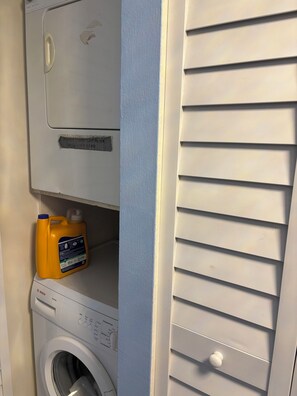 A laundry area with a Bosch washing machine and a detergent bottle. - Lovely 2-bedroom condo on the beach, fully furnished. (Satellite Beach)