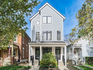 A two-story house with a front porch, a small garden, and a mailbox. - Luxury 6BR Townhome Duplex - Family Stay (Columbus)