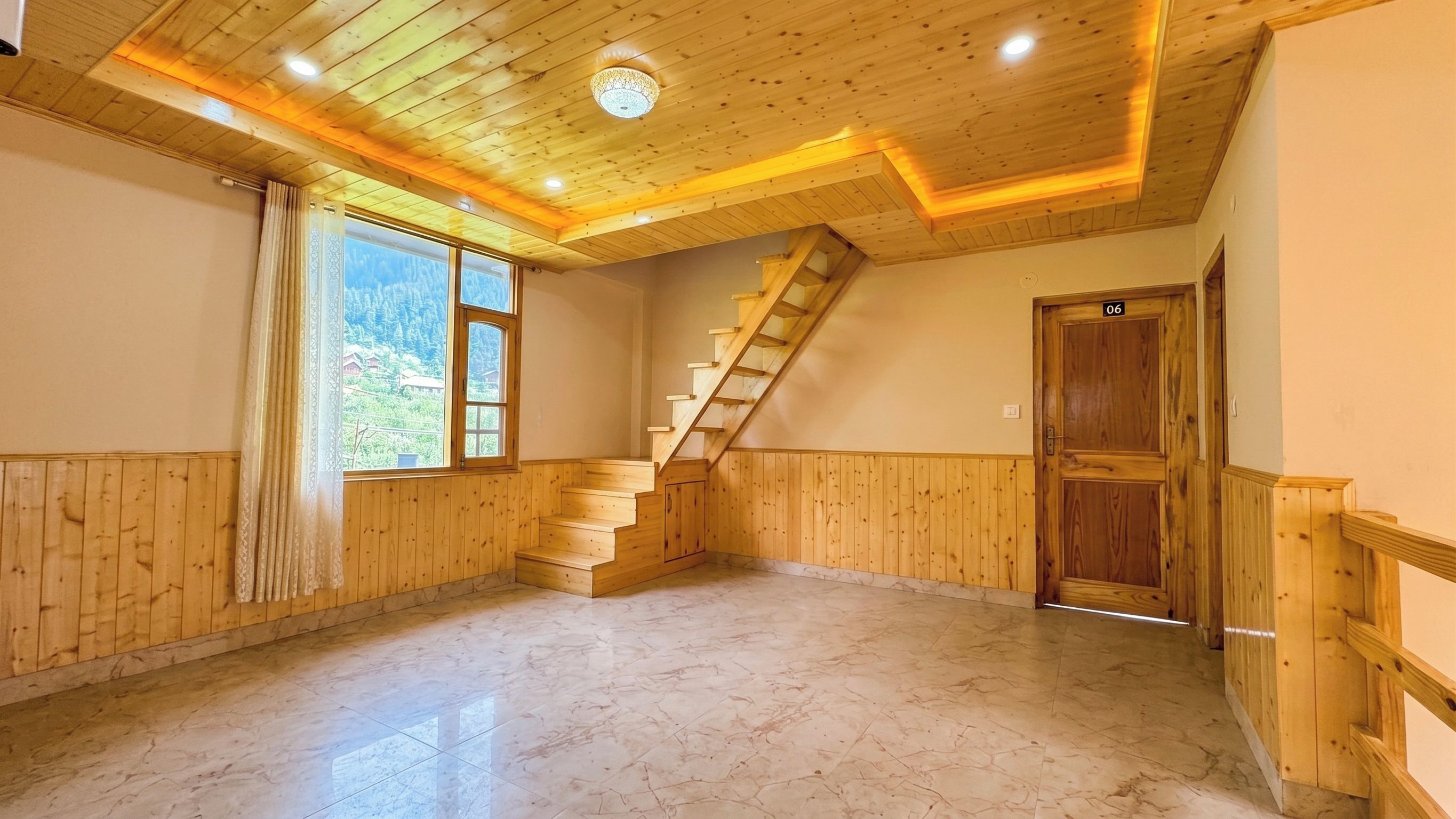 A room with wooden paneling, a marble floor, a wooden staircase, and a door marked with the number 06.