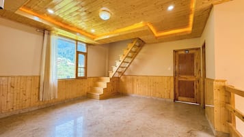 A room with wooden paneling, a marble floor, a wooden staircase, and a door marked with the number 06.