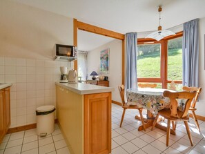 A kitchen with a dining area, a microwave, a coffee maker, and a view of the outdoors. - Central apartment in Morzine - 5 guests (Morzine)