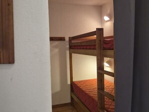A bunk bed with a wooden frame and a red mattress. - Quiet duplex apartment - 8 guests (Orcières Merlette)