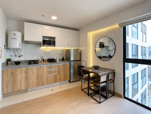 Eine moderne Küche mit integriertem Mikrowellenherd, Kühlschrank und Holzschränken.