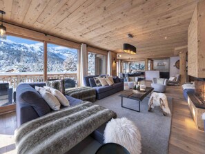 A spacious living area with a large sofa set, a coffee table, and a fireplace. - Spacious chalet with 6 bedrooms - 12 guests in Méribel (Méribel)