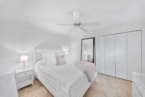 A bedroom with a bed, nightstand, lamp, ceiling fan, and wardrobe. - NEW! 3BR Park Shore Retreat w/ Large Pool & Patio (Naples)