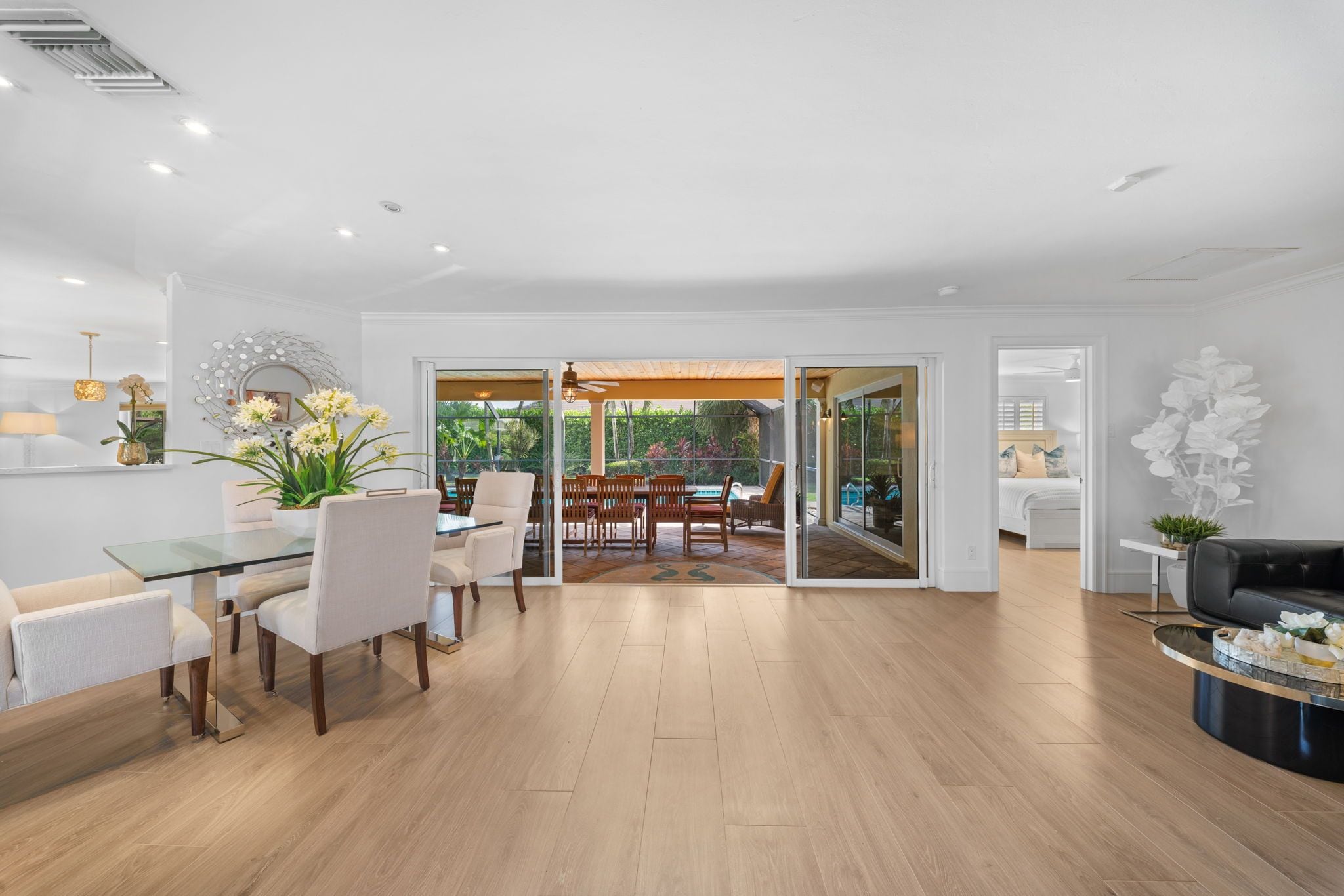 A spacious living area with a dining table and chairs, a sofa, and a coffee table.