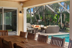 An outdoor patio with a pool, dining area, and seating. - NEW! 3BR Park Shore Retreat w/ Large Pool & Patio (Naples)
