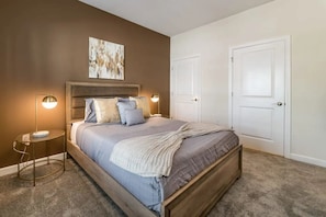 A bedroom with a bed, two bedside lamps, a headboard, and two doors. - Home w/ Private Pool Storey Lake Resort (Kissimmee)