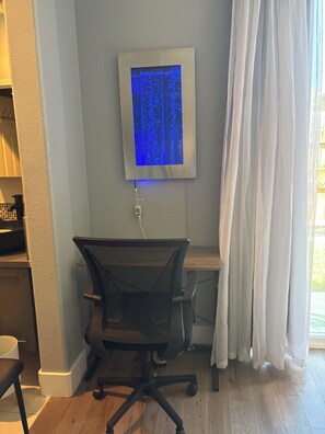 A room with a desk, chair, and a wall-mounted screen displaying a blue pattern. - Beautiful home in Antelope with private room, and private access. (Antelope)