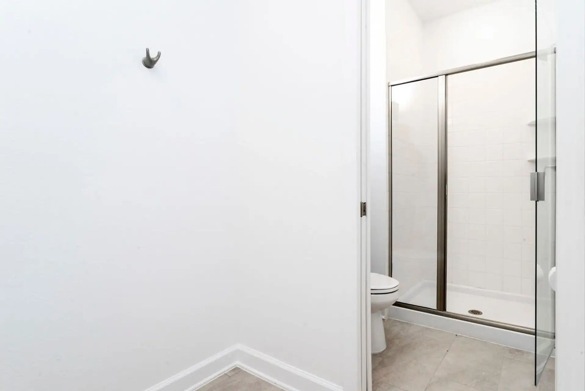 Une salle de bain avec une douche à parois de verre, des toilettes et un lavabo blanc.