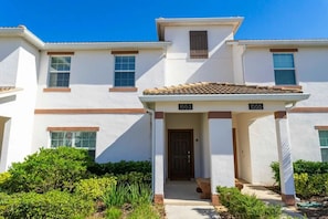 A two-story residential building with a covered entrance and a door marked with the number 1553. - 4BR Home With Private Pool & Disney Themes (Davenport)