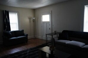 A living room with a sofa, a coffee table, and a floor lamp. - Delightful 2 bedroom townhouse in Hamlet (Hamlet)
