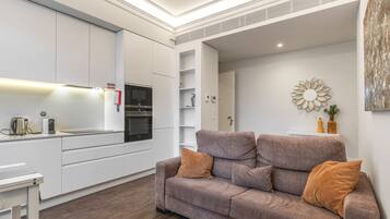 A modern kitchen with integrated appliances, a built-in oven, and a white countertop.
