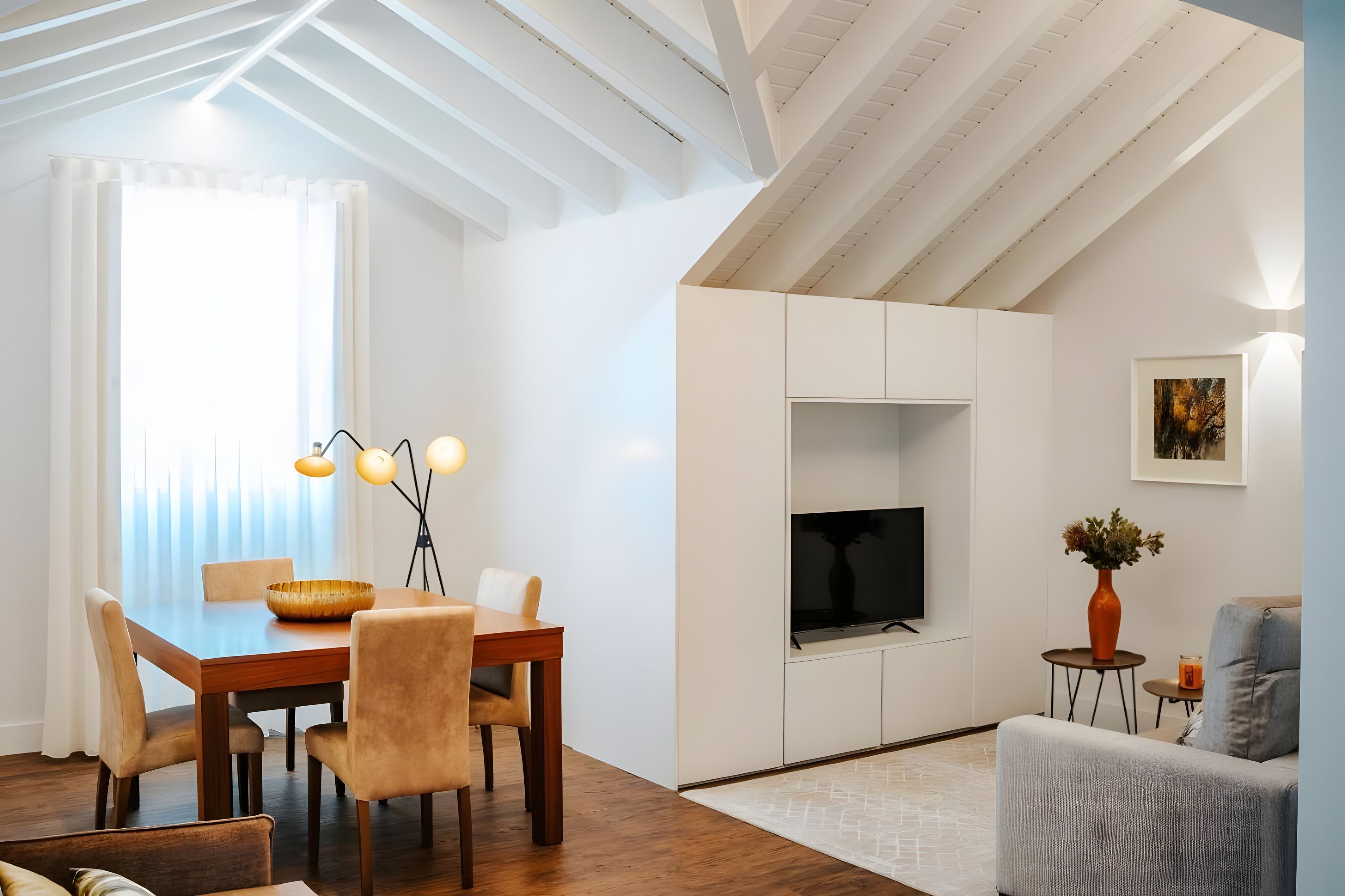 A modern interior with a dining area, a flat-screen TV, and a seating area with a sofa and a small table.