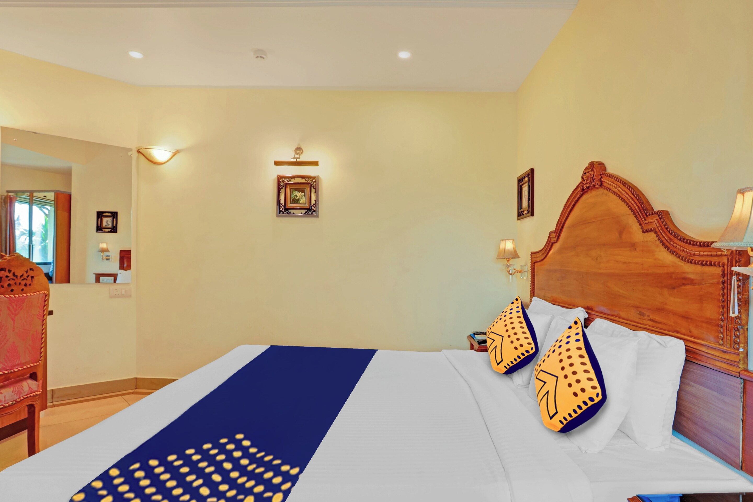 Ein Hotelzimmer mit einem großen Bett, einem hölzernen Kopfteil und einem Nachttisch mit einer Lampe.