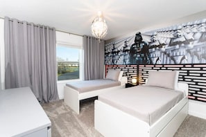 Ein Schlafzimmer mit Bett, einer Sitzbank, Wandmalerei und einem Fenster mit Vorhängen.