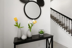 A staircase with a black railing and a wall-mounted circular mirror. - Townhome in Resort Pool Great Location (Kissimmee)