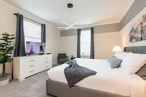 Une chambre d’hôtel moderne équipée d’un grand lit, d’une télévision, d’un bureau et d’une chaise.