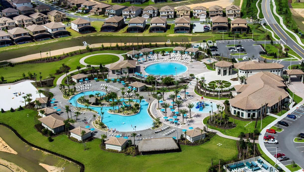 Eine Vogelperspektive eines Resorts mit mehreren Schwimmbecken, einem Innenhof und einem Parkplatz.