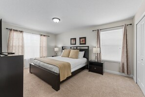 A bedroom with a bed, bedside tables, a dresser, and a window with curtains. - Storey Lake 6BR Villa w/ Private Pool & Spa (Kissimmee)