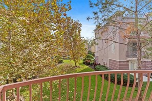 A residential building with a well-maintained lawn and trees. - 3-bedroom Townhouse at Vista Cay Resort (Orlando)