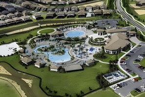 An aerial view of a residential area with two swimming pools, a landscaped park, and a parking lot. - 8BR Villa w/ Pool, Theater & Game Room (Davenport)
