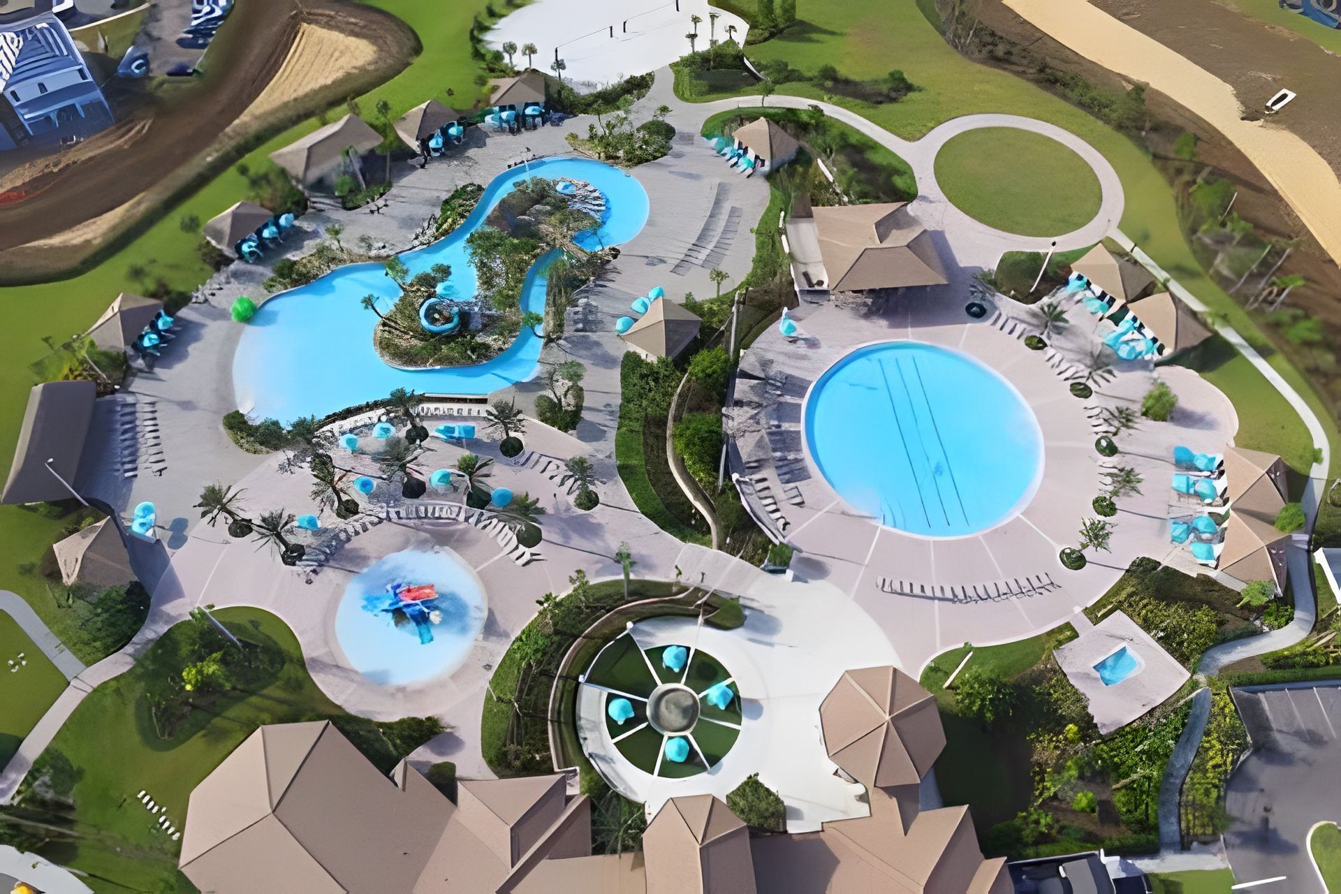 Luchtbeeld van een resort met meerdere zwembaden, lounges en een centraal waterkunstwerk.