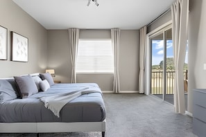 A modern bedroom with a large bed, a nightstand, a window with blinds, and a view of a balcony. - 3BR Villa w/ Resort Access Near Disney (Davenport)