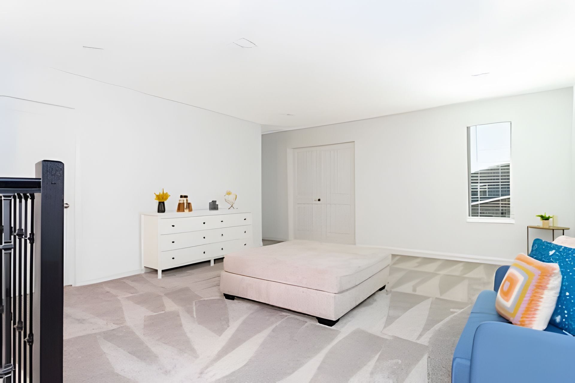 A bedroom with a bed, a dresser, a wardrobe, a window, and a sofa.